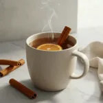 A warm, steaming Cinnamon Tea Recipe garnished with an orange slice in a cozy mug.