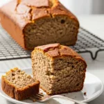 A thick slice of moist banana bread made with cake mix on a white plate, showing the tender texture.