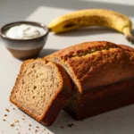 A moist banana bread recipe with yogurt, shown as a sliced loaf on a cooling rack.