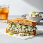 A close up of a classic chicken salad recipe sandwich on toasted sourdough bread.