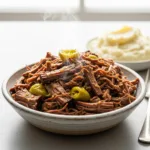 A close up 45-degree angle shot of a bowl filled with tender, juicy Mississippi pot roast, ready to be served.