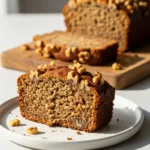 A thick slice of moist protein banana bread on a white plate, showing its tender texture.