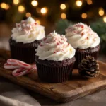 Three festive chocolate peppermint cupcakes arranged on a plate. These are the perfect example of delicious Christmas recipes.