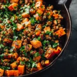 An extreme close-up, top-down view of a savory ground turkey sweet potato skillet, showing the texture of the browned turkey and tender sweet potatoes.