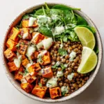 A close-up view of the healthy sweet potato lentil bowl, showing the texture of the roasted sweet potatoes, quinoa, and creamy dressing.