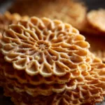 Pizzelle Recipe (The Easiest Way to Make Thin & Crispy Italian Cookies) A close-up macro shot of a stack of freshly made traditional pizzelle, showing their delicate, crisp texture.