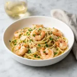 A bowl of garlic butter shrimp pasta without cream, garnished with fresh parsley and Parmesan.