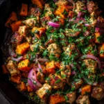 One-Pan Garlic Herb Chicken: The Perfect Weeknight Dinner An extreme close-up overhead shot of a rustic cast iron skillet with golden-brown One-Pan Garlic Herb Chicken, potatoes, and broccoli.