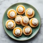 A flat lay of soft pumpkin cookies on a cooling rack before being frosted. The cookies have a beautiful golden-brown edge.