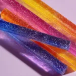 A close-up macro shot of translucent alcoholic gummies, highlighting their perfect texture and lime green color.