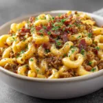 Bacon Cheeseburger Pasta: The Ultimate One-Pot Comfort Meal A spoonful of cheesy beef pasta being lifted from a bowl, showing the creamy texture of the Bacon Cheeseburger Pasta sauce.