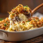 French Onion Beef Casserole: The Ultimate Comfort Meal A close-up spoonful of the French Onion Beef Casserole, showcasing the rich beef and onion filling under the melted cheese.