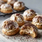 A close-up shot of several Tiramisu Crinkle Cookies on a plate, showing their perfect crinkled tops and rich color.