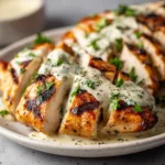 A close-up shot of sliced grilled Caesar chicken breast, highlighting the tender and moist texture of the meat.