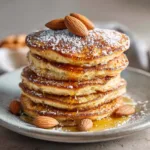 A perfect stack of golden-brown healthy almond flour pancakes, showcasing their light and fluffy texture.