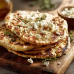 A stack of freshly made high-protein flatbread, showing its flexible texture and golden-brown surface.