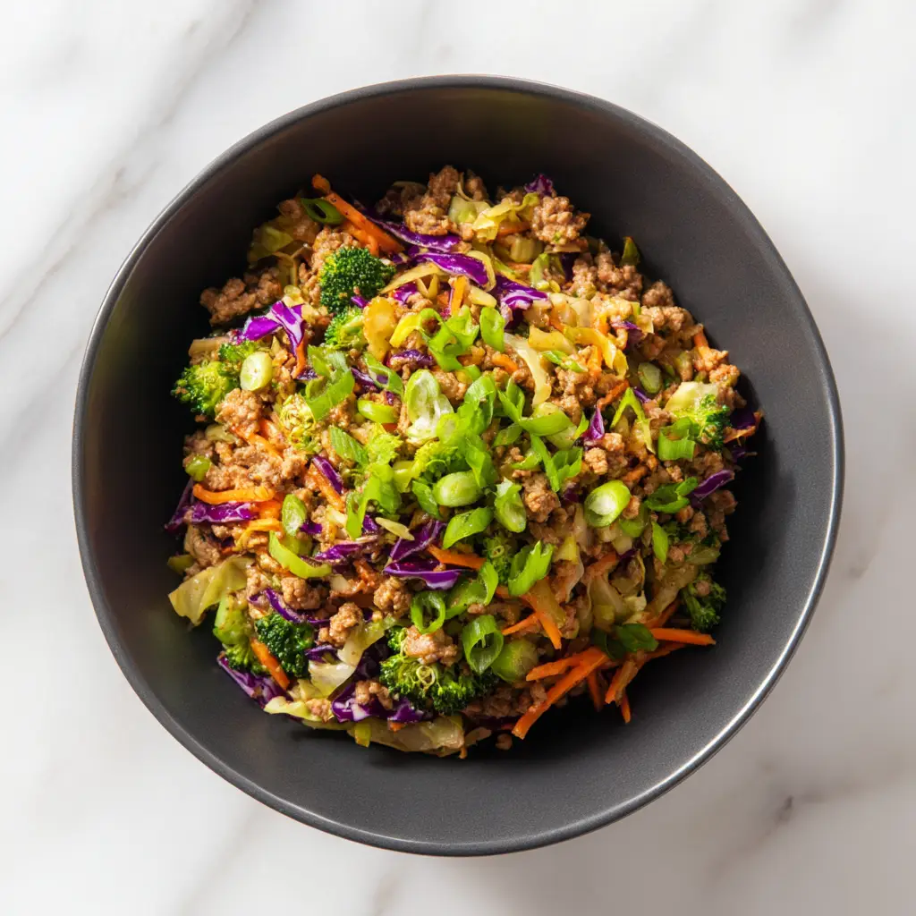 High Protein Egg Roll in a Bowl (The Ultimate Recipe!) 3 An overhead shot of the high protein egg roll in a bowl in a skillet, showcasing the colorful mix of ground turkey, cabbage, and carrots. A healthy stir fry meal.