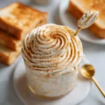An overhead close-up shot of fluffy, whipped Texas Roadhouse Cinnamon Honey Butter in a small white bowl, ready to be served.