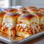 Ingredients for Buffalo Chicken Sliders including Hawaiian rolls, shredded chicken, buffalo sauce, and white provolone cheese.