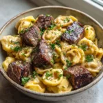 Plump cheese tortellini and thick seared beef steak bites heavily coated in a thick, rich garlic sauce, garnished with parsley and cracked black pepper. (Garlic Steak Tortellini)