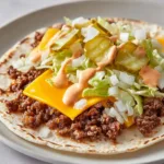 An unedited, handheld smartphone photo showing the thick creamy orange-pink secret sauce with visible sweet pickle relish flecks drizzled over a Big Mac Wrap.