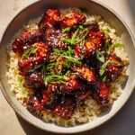 A close-up overhead shot of a shallow matte ceramic bowl filled with Honey BBQ Chicken Rice. The chicken has charred, caramelized edges.