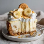 Close up of a thick slice of No-Bake Banana Pudding Cheesecake showing the pale-yellow filling with banana specks.