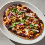 Close up view of seared chicken and melted cheese on a BBQ Chicken Flatbread Recipe.