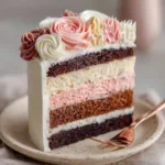 Close-up of a Neapolitan cake slice showing dark chocolate, milk chocolate, strawberry, and vanilla layers. (Neapolitan Cake Recipe)