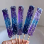 Vertical gummy candy wands showing a firm and chewy texture with a sugar-glitter coating. (Tequila Gummy Wands)