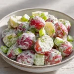 Salt and Vinegar Potato Salad with Fresh Dill and Crunchy Celery Close-up handheld smartphone photo of Salt and Vinegar Potato Salad in a white ceramic bowl featuring tender halved red potatoes and fresh dill.