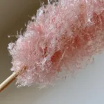 Homemade Cotton Candy Without a Machine: The Secret to Fluffy Spun Sugar Fine delicate spun sugar threads held over a clean kitchen counter. (Homemade Cotton Candy Without a Machine)