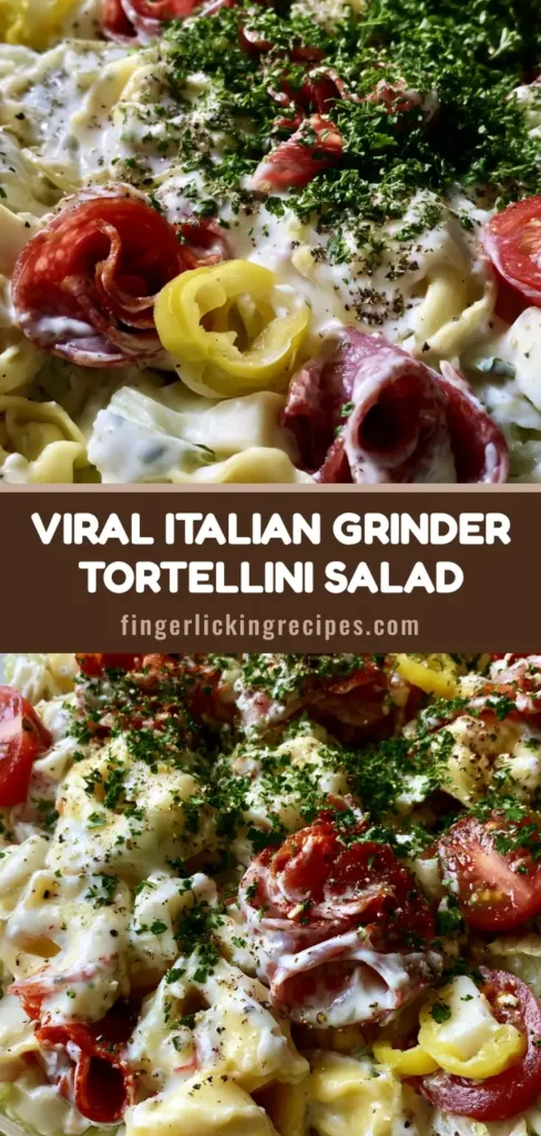A towering glass bowl of Italian Grinder Tortellini Salad with glossy creamy dressing, bright red tomatoes, and fresh parsley garnish.