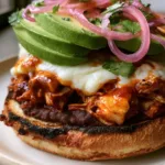 Chipotle Chicken Torta Recipe: The Ultimate Mexican Street Food Experience Close-up of shredded chicken drenched in glossy orange-red chipotle sauce inside a Chipotle Chicken Torta.