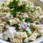 Creamy Chicken Pasta Salad with Fresh Dill and Sweet Peas Close-up view of Creamy Chicken Pasta Salad showing the thick velvety dressing and bright green peas.