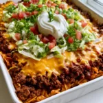 Walking Taco Casserole: The Ultimate Crispy & Cheesy Family Dinner Close-up of Walking Taco Casserole layers showing crispy Fritos, seasoned beef, and bubbly melted orange cheddar cheese.