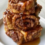 Cinnamon Roll French Toast Roll-Ups: The Ultimate Buttery Sourdough Breakfast Close up photo of the tightly coiled sourdough bread showing the golden-brown crispy exterior of Cinnamon Roll French Toast Roll-Ups.
