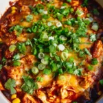Slow Cooker Chicken Enchilada Casserole with Melty Monterey Jack and Sharp Cheddar Close-up of shredded white meat chicken, black beans, and corn in a glossy red sauce for a Slow Cooker Chicken Enchilada Casserole.