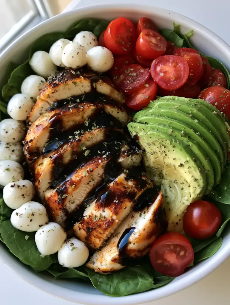 Baked Chicken Salad with Balsamic Glaze and Fresh Mozzarella 2 Close-up of thick balsamic glaze drizzled over a fresh Baked Chicken Salad with avocado and spinach.