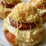 Filipino Ensaymada Recipe: The Ultimate Guide to Soft, Cheesy Brioche Perfection Close-up of golden-brown spiraled Ensaymada rolls on a white plate with visible airy crumb. (Filipino Ensaymada Recipe)