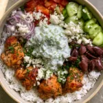 Chicken Gyro Bowls: The Ultimate Mediterranean Meal Prep Solution Overhead smartphone photo of Chicken Gyro Bowls featuring distinct sections of golden chicken, fresh veggies, and creamy tzatziki on a bed of fluffy rice.