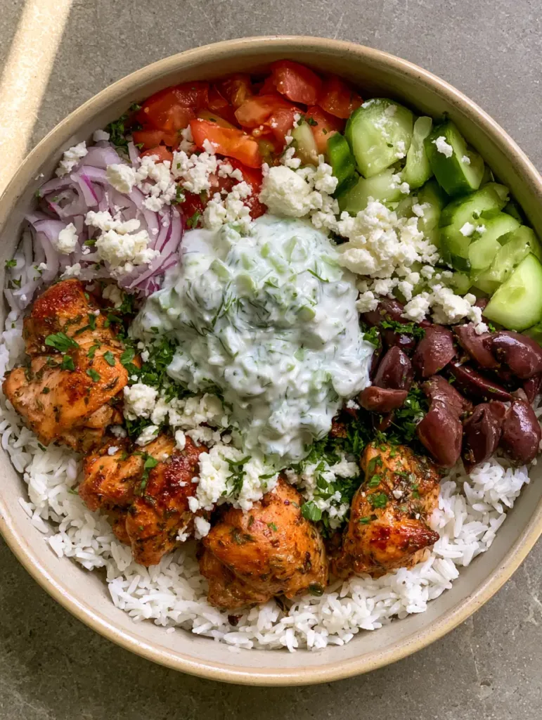 Chicken Gyro Bowls: The Ultimate Mediterranean Meal Prep Solution 3 Overhead smartphone photo of Chicken Gyro Bowls featuring distinct sections of golden chicken, fresh veggies, and creamy tzatziki on a bed of fluffy rice.