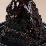 Dark Chocolate Mount Doom Cake: A Molten Lava Masterpiece Close-up of the porous charcoal crumb of the Dark Chocolate Mount Doom Cake.