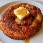 Handheld photo of a thick French Toast Cookie with a heavy cinnamon sugar coating and maple syrup drizzle. (French Toast Cookies)